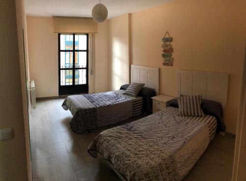 a hotel room with two beds and a window at San Juan de la Cruz in Ávila
