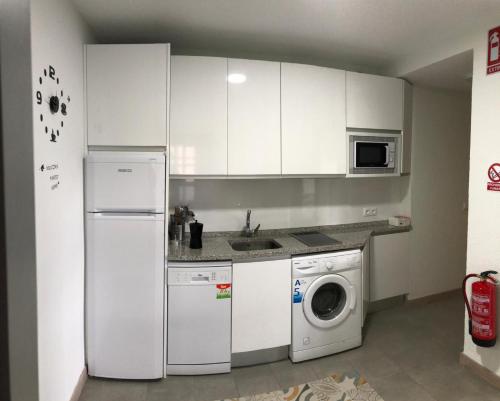 a kitchen with a white refrigerator and a washing machine at San Juan de la Cruz in Ávila