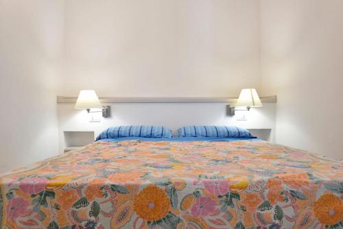 a bedroom with a large bed with a colorful bedspread at VILLA MILVIO con accesso privato in spiaggia in Tortolì