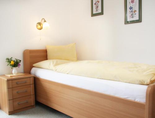 a bed with a wooden frame and a nightstand with a bed sidx sidx sidx at Hotel-Restaurant Stefanihof in Fuschl am See