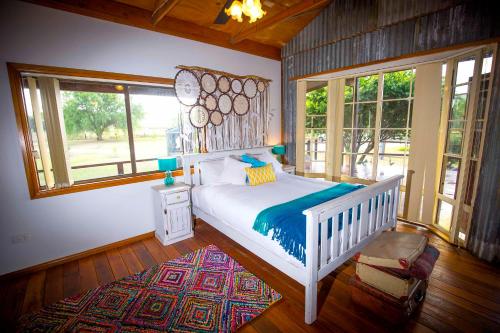 een slaapkamer met een wit bed en een groot raam bij Peppercorn Cabin in Broke