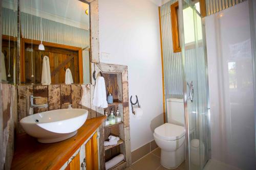 a bathroom with a sink and a toilet at Peppercorn Cabin in Broke