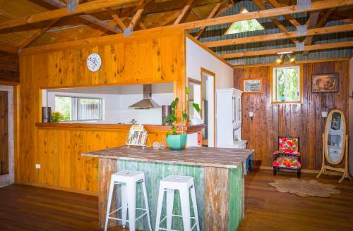a kitchen with a counter and stools in a room at Peppercorn Cabin in Broke