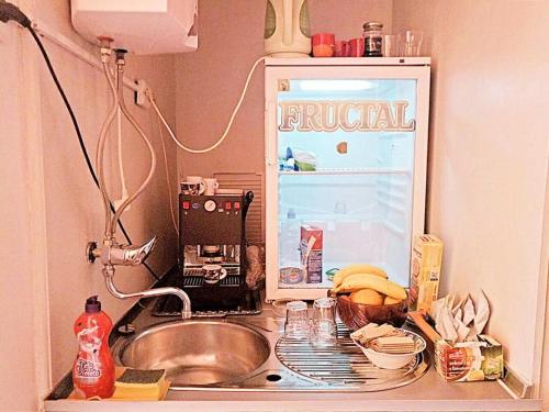 a kitchen counter with a sink and a refrigerator at Sarajevo Rooms in Sarajevo