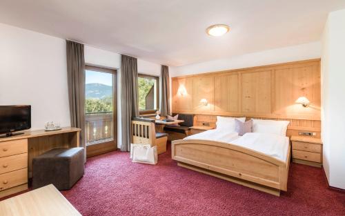 um quarto com uma cama e uma grande janela em Hotel Weisses Rössl 3Sup em Laion