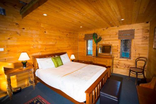 a bedroom with a bed in a wooden cabin at Red Tractor Retreat in Broke