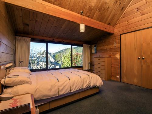 a bedroom with a large bed with a large window at mulberry house in Picton