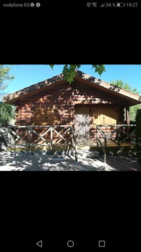 einem Blockhaus mit einem Tor davor in der Unterkunft Cabañas rurales la vega in Burunchel
