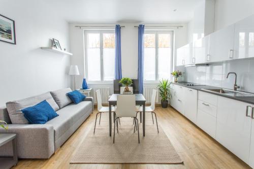 une cuisine et un salon avec un canapé et une table dans l'établissement Appartement Vacances Picardie, à Amiens