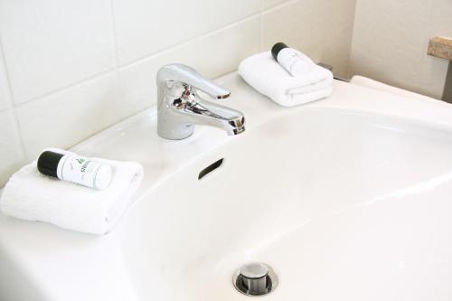 a bathroom sink with a roll of toilet paper on it at Hotel-Restaurant Stefanihof in Fuschl am See