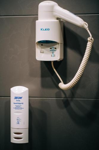 a klee phone on a wall next to a cup at Boutique Hotel Golden Star in Tuzla