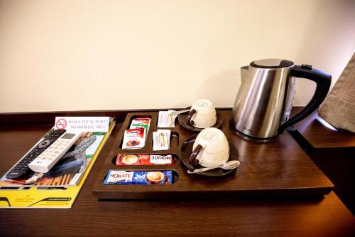 a table with a coffee maker and a tea kettle at Boutique Hotel Golden Star in Tuzla