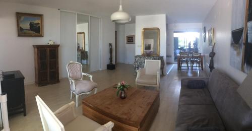 uma sala de estar com um sofá e uma mesa em Vue exceptionnelle sur les Tours ! Charme et tranquillité em La Rochelle