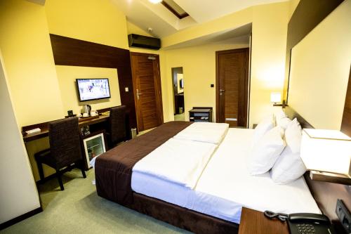 a hotel room with a bed and a desk at Boutique Hotel Golden Star in Tuzla