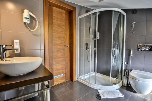 a bathroom with a shower and a sink at Boutique Hotel Golden Star in Tuzla