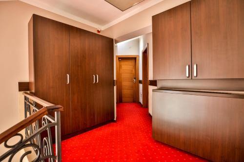 a hallway with wooden cabinets and a red carpet at Boutique Hotel Golden Star in Tuzla