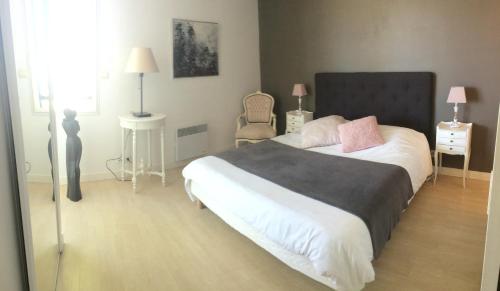 a bedroom with a large bed and a chair at Vue exceptionnelle sur les Tours ! Charme et tranquillité in La Rochelle