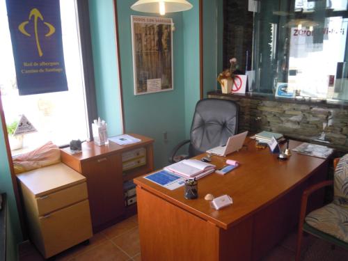 an office with a desk with a laptop on it at Albergue O Durmiñento in Sarria