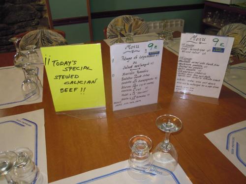 a table with signs and wine glasses on it at Albergue O Durmiñento in Sarria