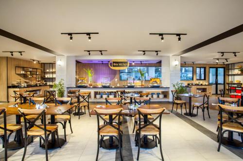 a restaurant with tables and chairs and a bar at ibis Pontianak City Center in Pontianak