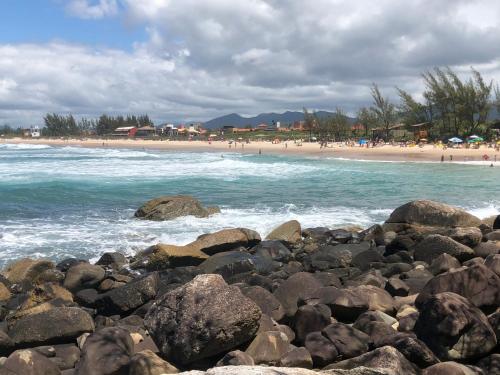 a group of rocks on a beach with the ocean at Pousada Bem te vi in Garopaba