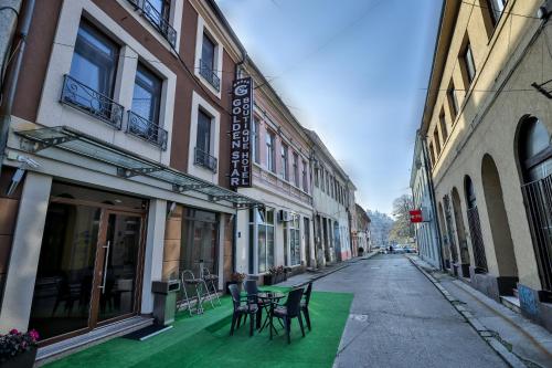 an empty alley with chairs and tables on a street at Boutique Hotel Golden Star in Tuzla
