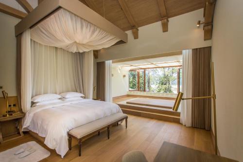 a bedroom with a large bed and a window at Evergreen Retreat-walk to National Forest Park, free pick up service in Zhangjiajie