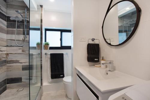 Baño blanco con lavabo y espejo en Absolute Beach Front Renovated 3 Bdrm 2 Bath App, en Gold Coast
