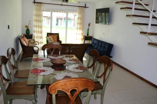 a dining room with a glass table and chairs at Villa exclusiva en Ixtapa a unos pasos del mar in Ixtapa