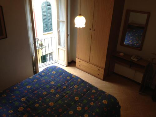 een slaapkamer met een bed en een raam bij Albergo Il Vapore in Menaggio