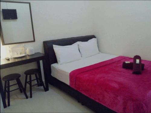 a bedroom with a bed and a table and stool at Rasa Senang Villa -Islam Guest Only in Pantai Cenang