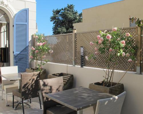 einen Tisch und Stühle mit Blumen auf der Terrasse in der Unterkunft Hotel Le Havre Bleu in Beaulieu-sur-Mer