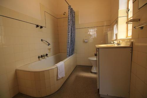 ein Badezimmer mit einer Badewanne, einem WC und einem Waschbecken in der Unterkunft Beer Deluxe Albury in Albury