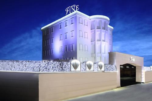 a white building with a sign on top of it at Hotel Fine Garden Okayama I in Okayama