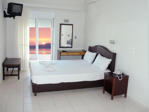 a bedroom with a bed and a television in it at Hotel Plaza in Nea Stira