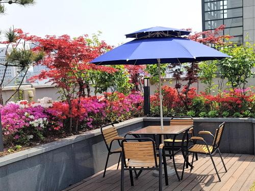 a table and chairs with an umbrella on a patio at Hotel Nafore in Seoul