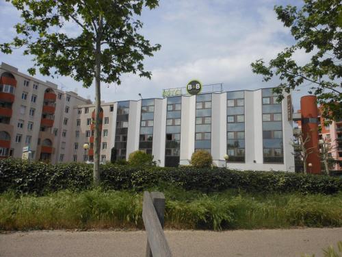 a large white building with a clock on it at B&B HOTEL Toulouse Centre Canal du Midi in Toulouse