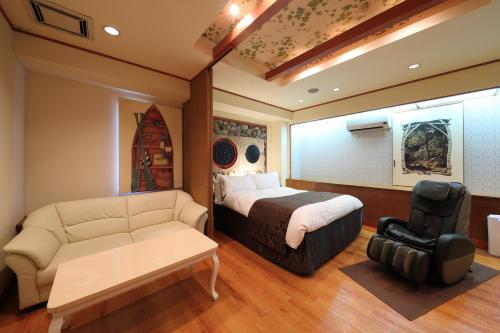 a hotel room with a bed and a couch at Hotel Fine Garden Okayama II in Okayama