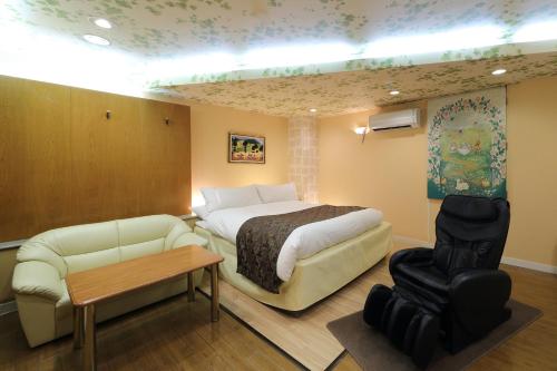 a hotel room with a bed and a couch at Hotel Fine Garden Okayama II in Okayama