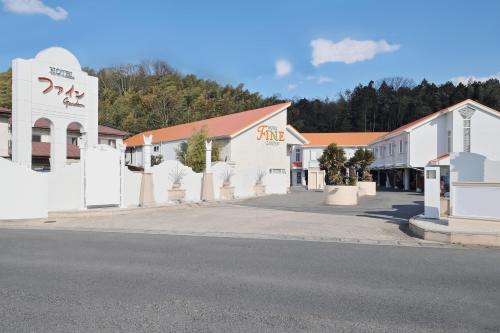 a row of white buildings on the side of a street at Hotel Fine Garden Kosei (Adult Only) in Konan