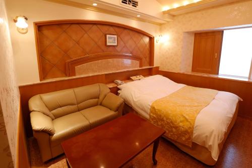 a hotel room with a bed and a chair at Hotel Fine Garden Kosei (Adult Only) in Konan