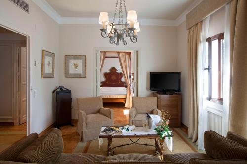 a living room with a couch and a table and a bed at Parador de Teruel in Teruel