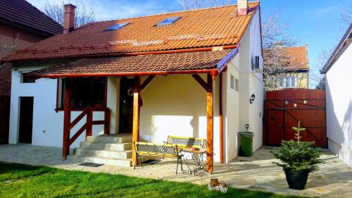 a house with a pavilion with a bench in the yard at Zozo House in Braşov