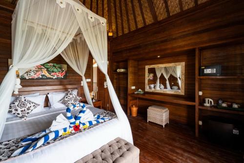 a bedroom with two beds with mosquito nets at Sunset Cave Villas Lembongan in Nusa Lembongan
