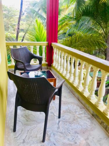 a balcony with two chairs and a table at LaligurasVilla Beachside Escape - 100m to Beach in Candolim