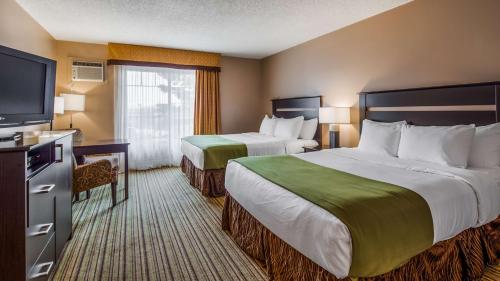 a hotel room with two beds and a flat screen tv at Best Western Plus Mont-Laurier in Mont-Laurier