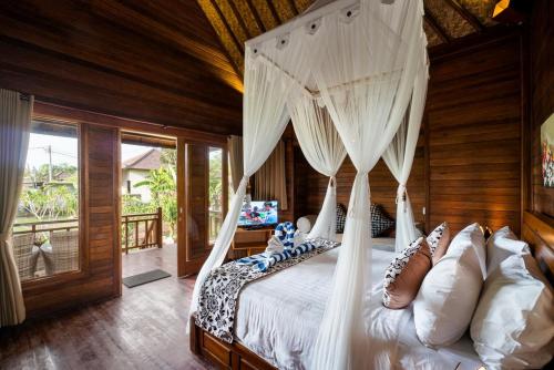 um quarto com uma cama e uma rede mosquiteira em Sunset Cave Villas Lembongan em Nusa Lembongan