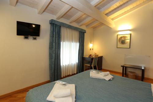 una camera da letto con un letto e due asciugamani di Rigel Hotel a Catania