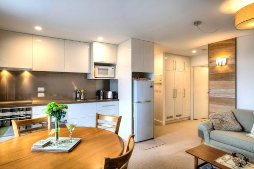 een keuken en woonkamer met een tafel en een bank bij Les Chalets 20 in Falls Creek