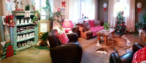 a living room with christmas trees and a couch at Hôtel du Haut Koenigsbourg- entre vignes et château in Thannenkirch